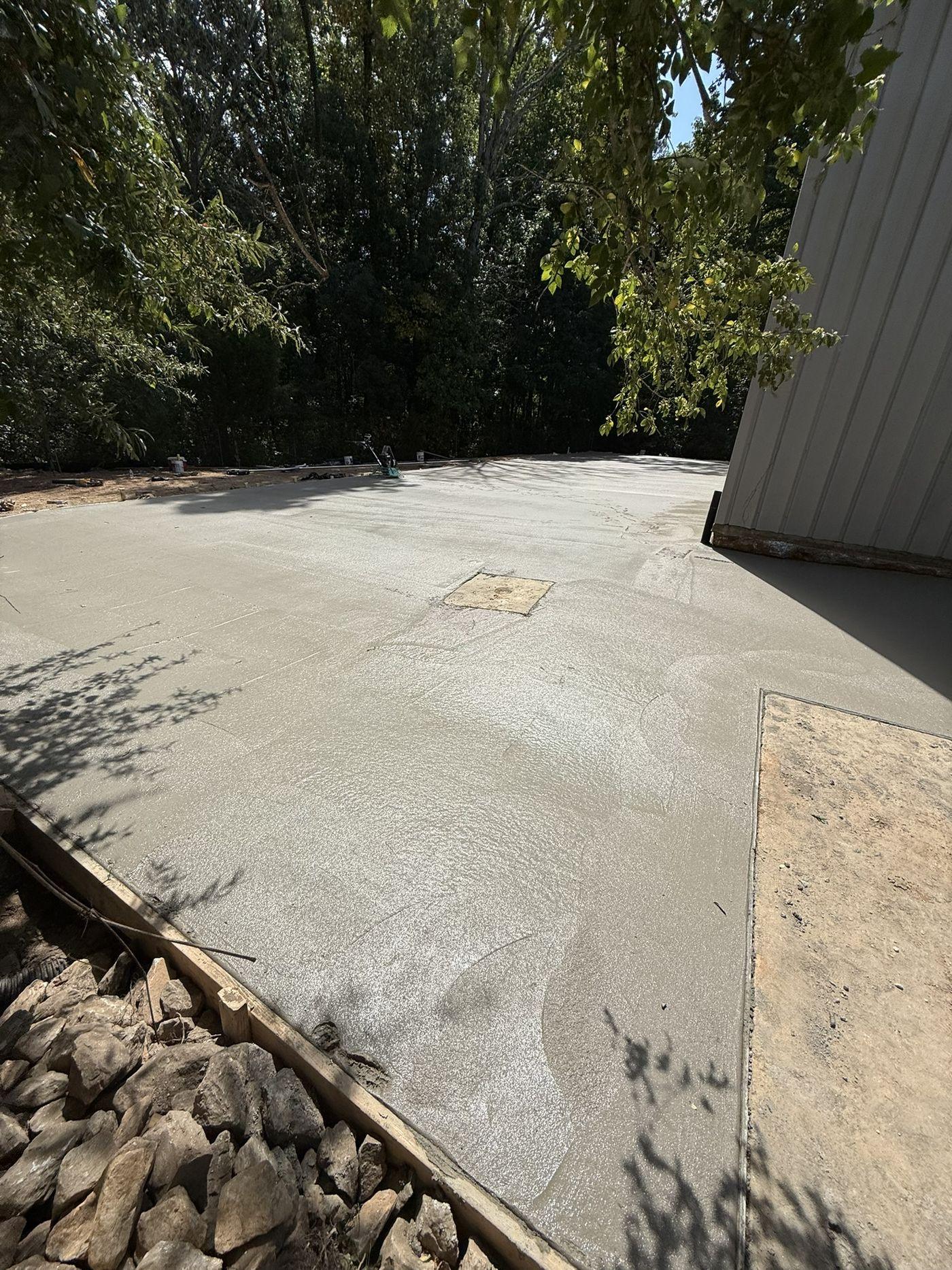 Finished commercial concrete slab cured and swept alongside a metal building