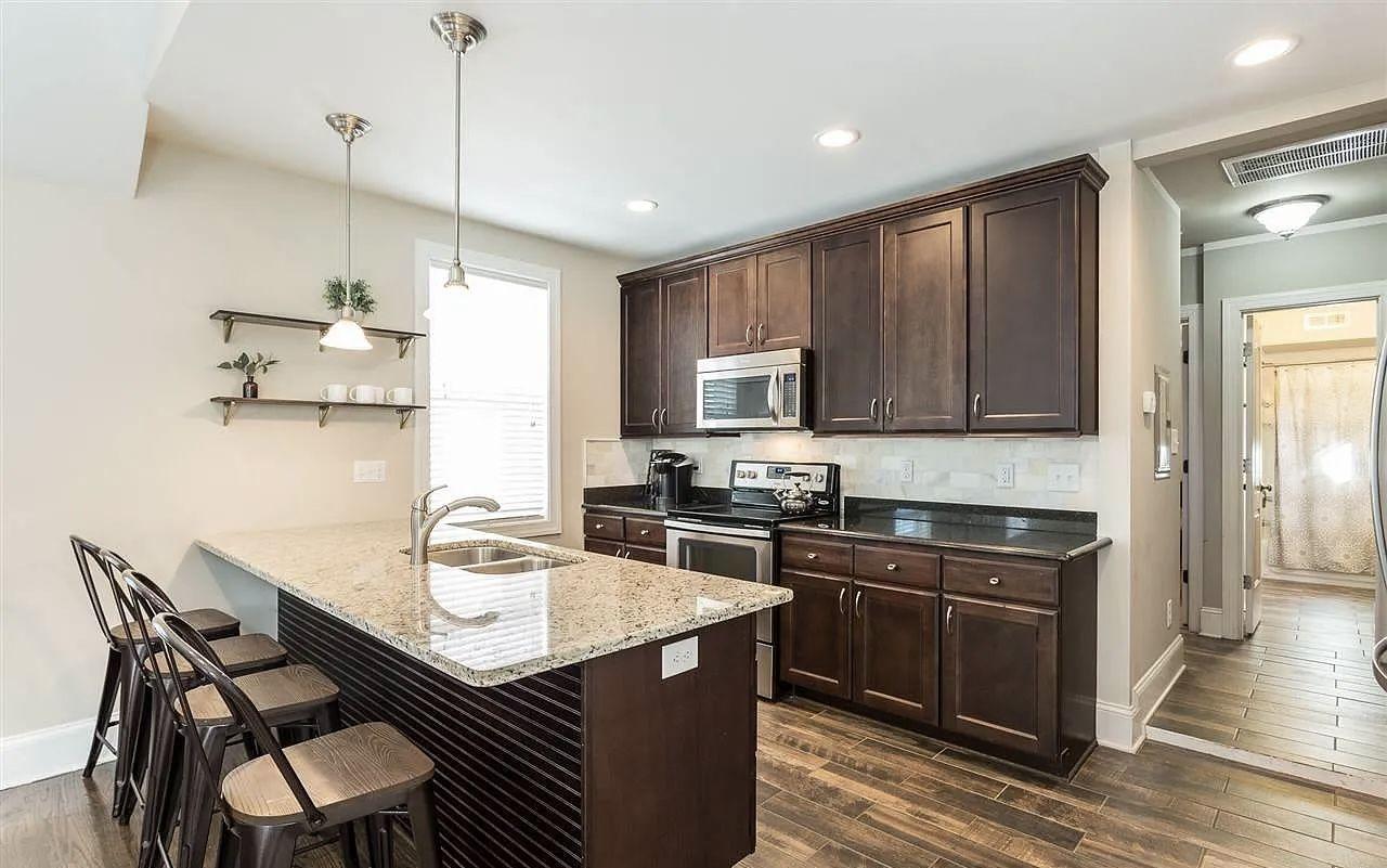 Remodelled kitchen with a granite-topped island, bar seating and stainless appliances