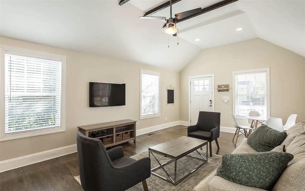 Open living area of a fully renovated home with exposed beams and refinished floors