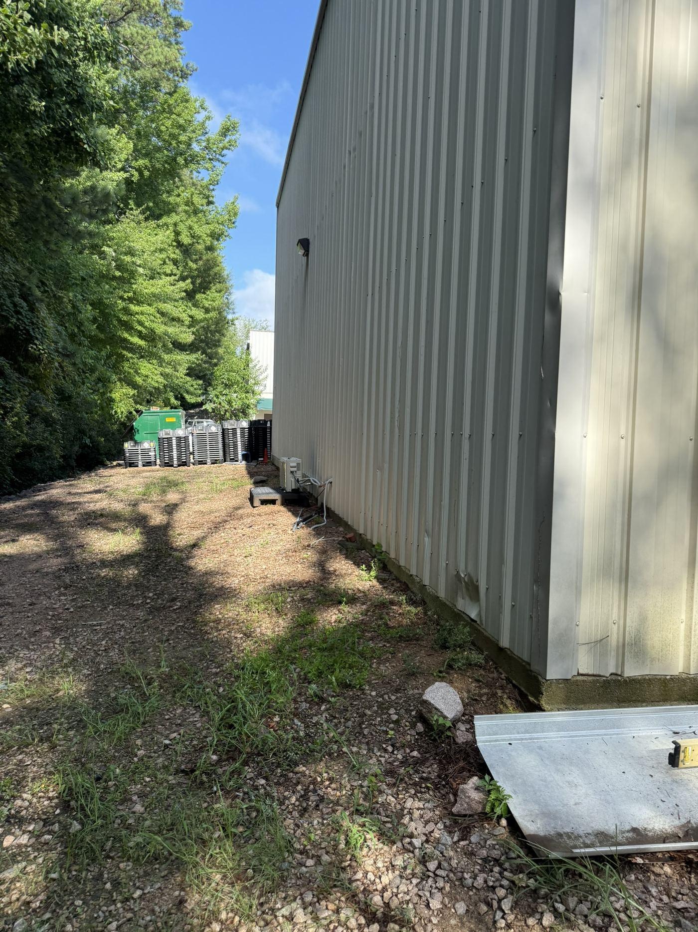 The unimproved strip of ground alongside the commercial building before work began