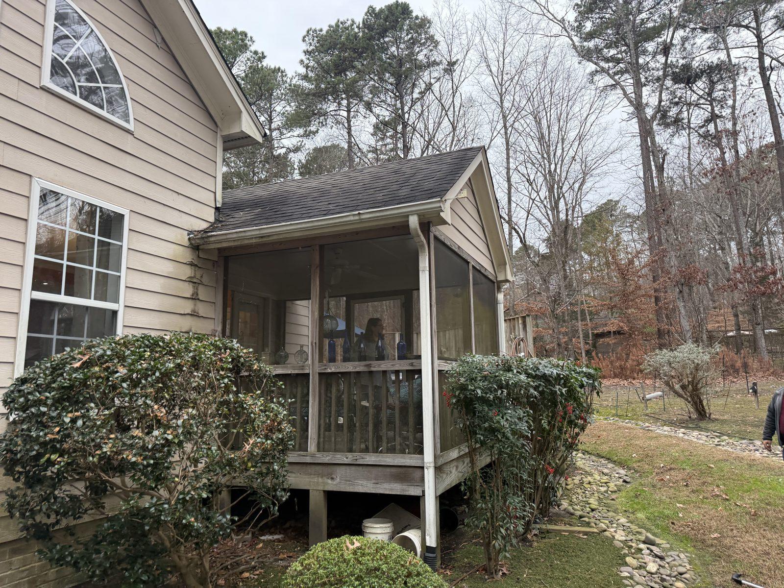 The original screened porch, weathered and carried on timber posts, before removal