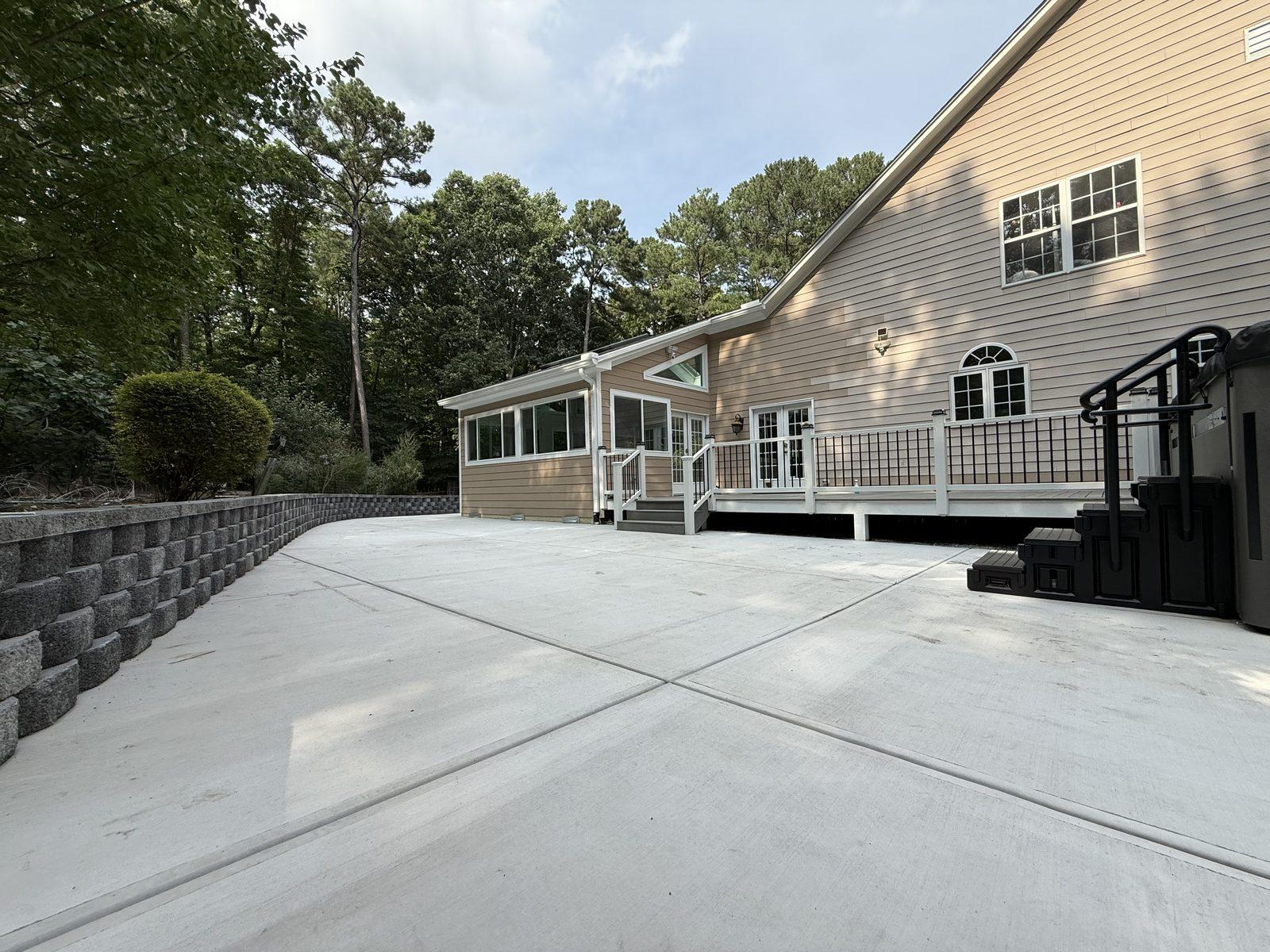 The poured concrete patio running back from the house to a segmental block retaining wall
