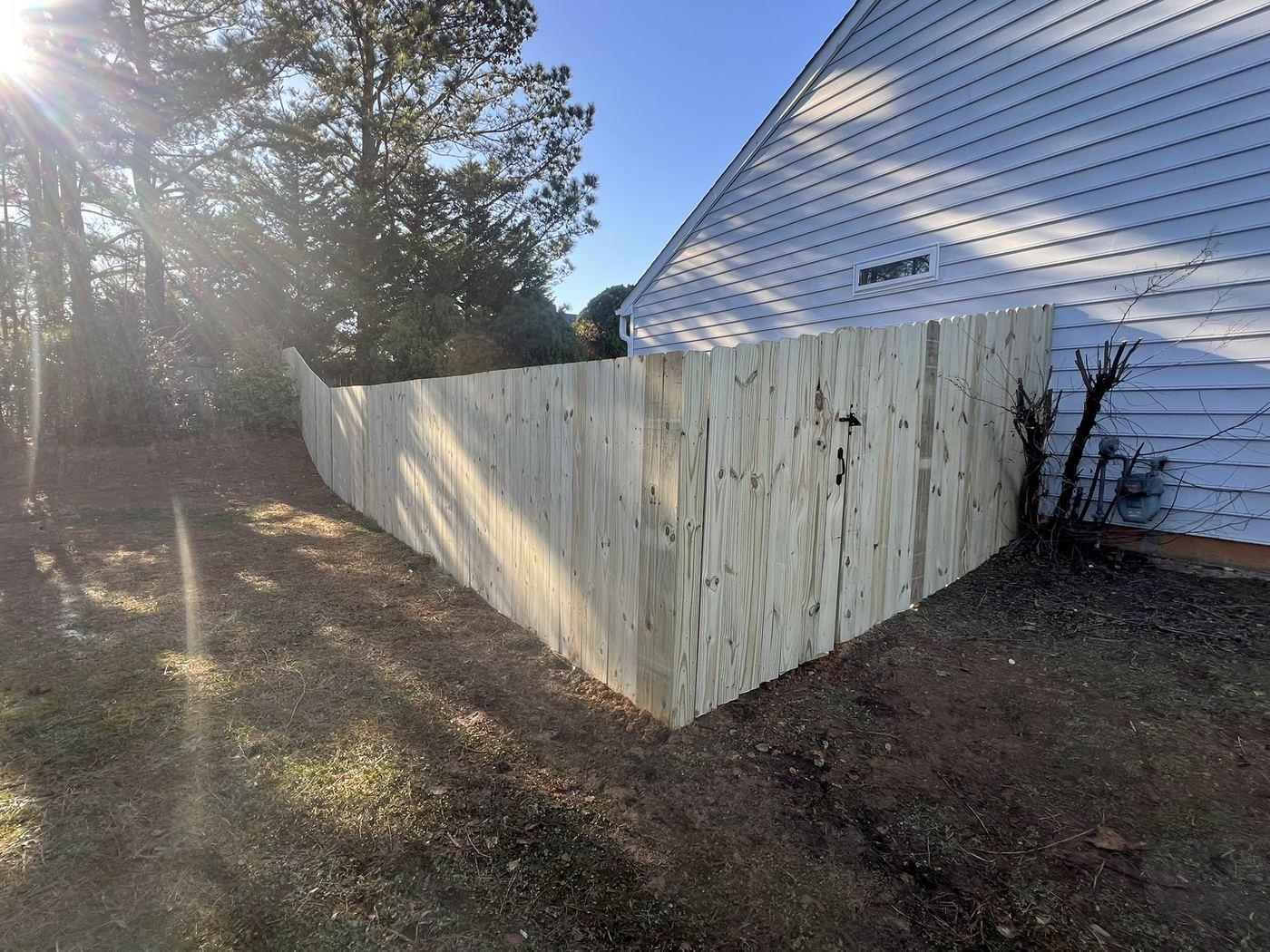 Completed timber privacy fence running along a property boundary beside a house