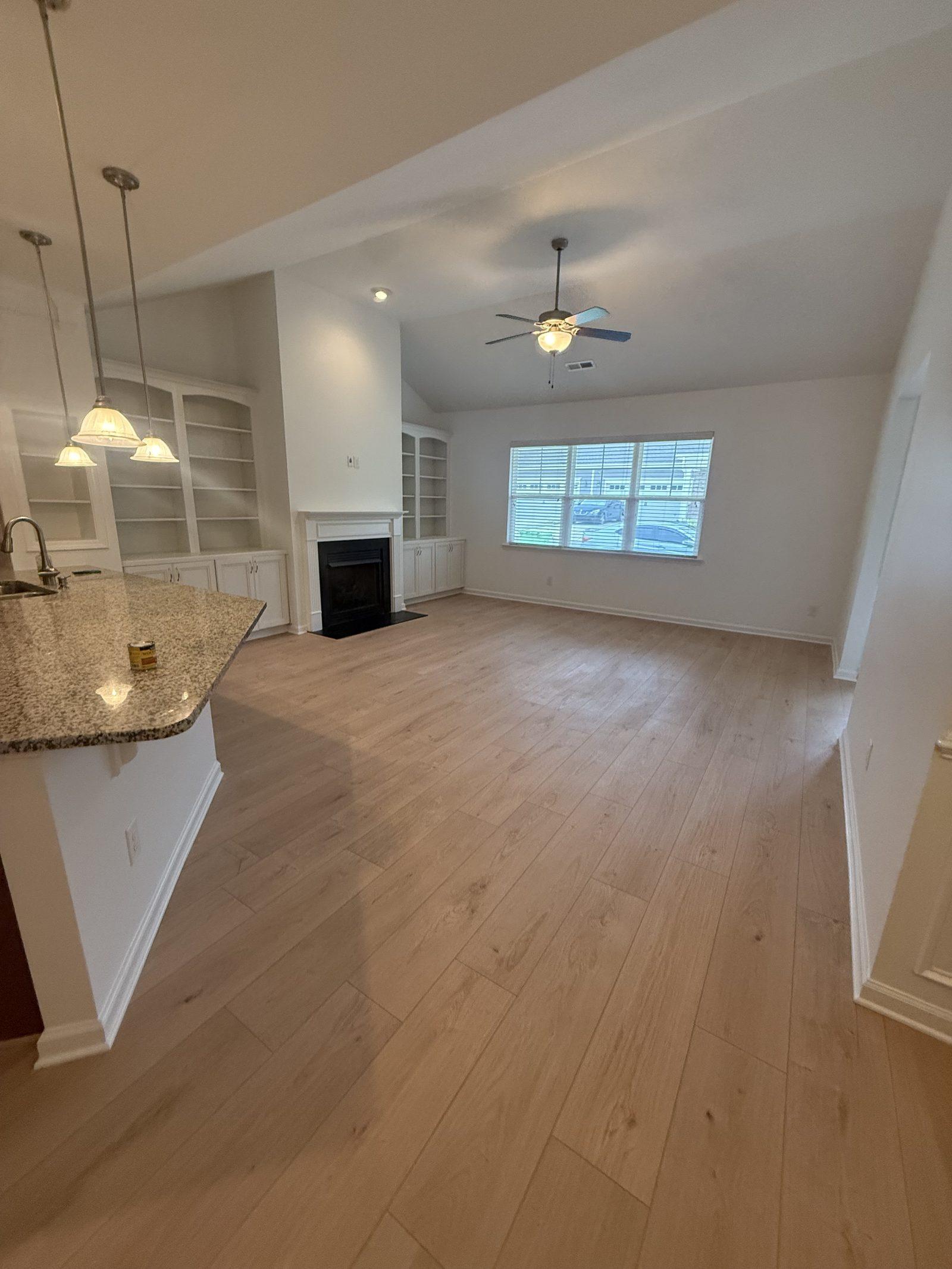 The open-plan kitchen and living space with the finished floor running unbroken between them
