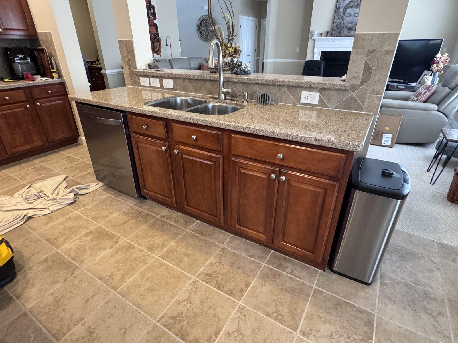 The same island rebuilt, with new cabinet boxes, the stone countertop refitted and the sink and dishwasher back in