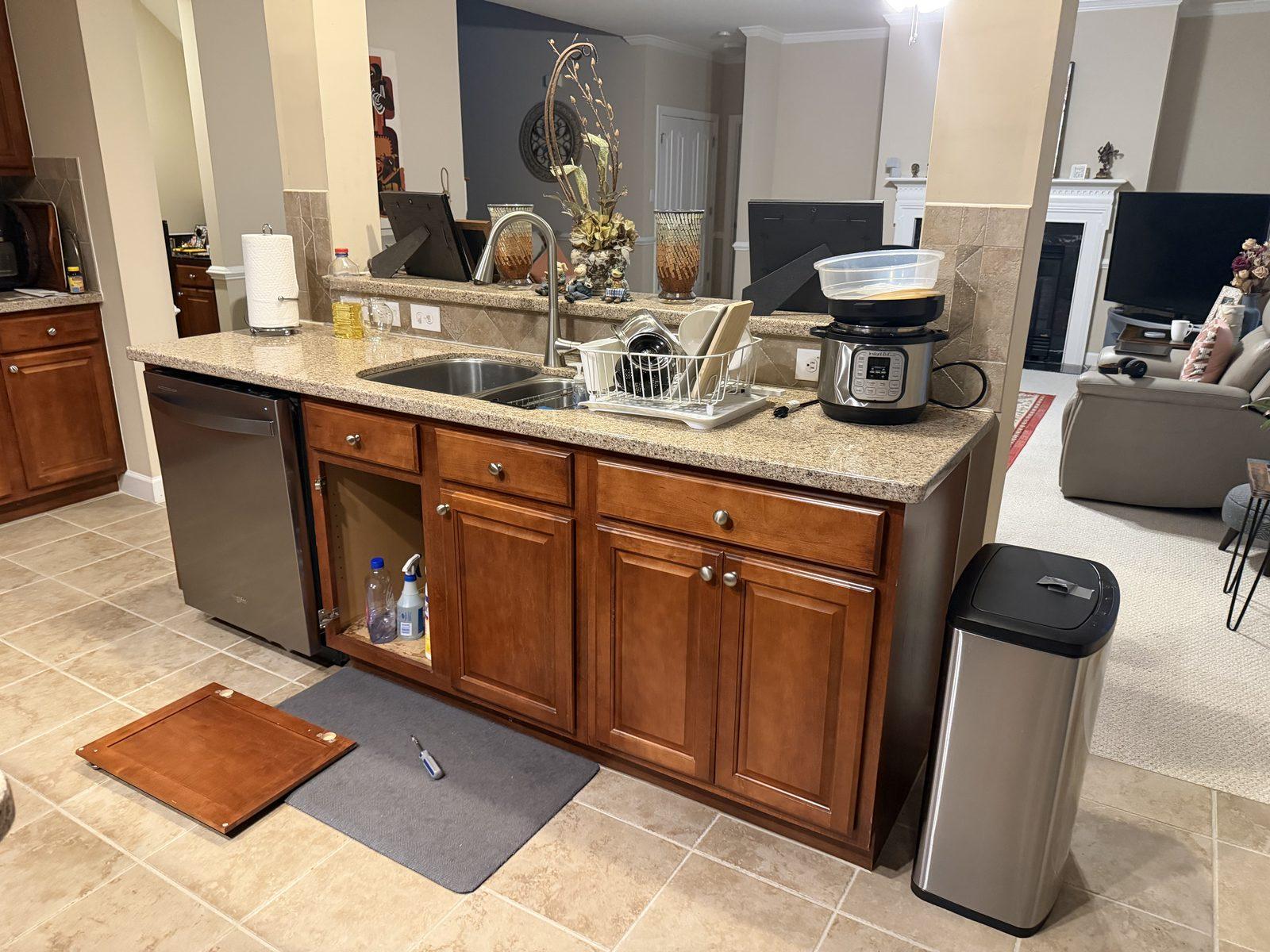 The island as found, with the original cabinetry and dishwasher in place and the sink base already opened up