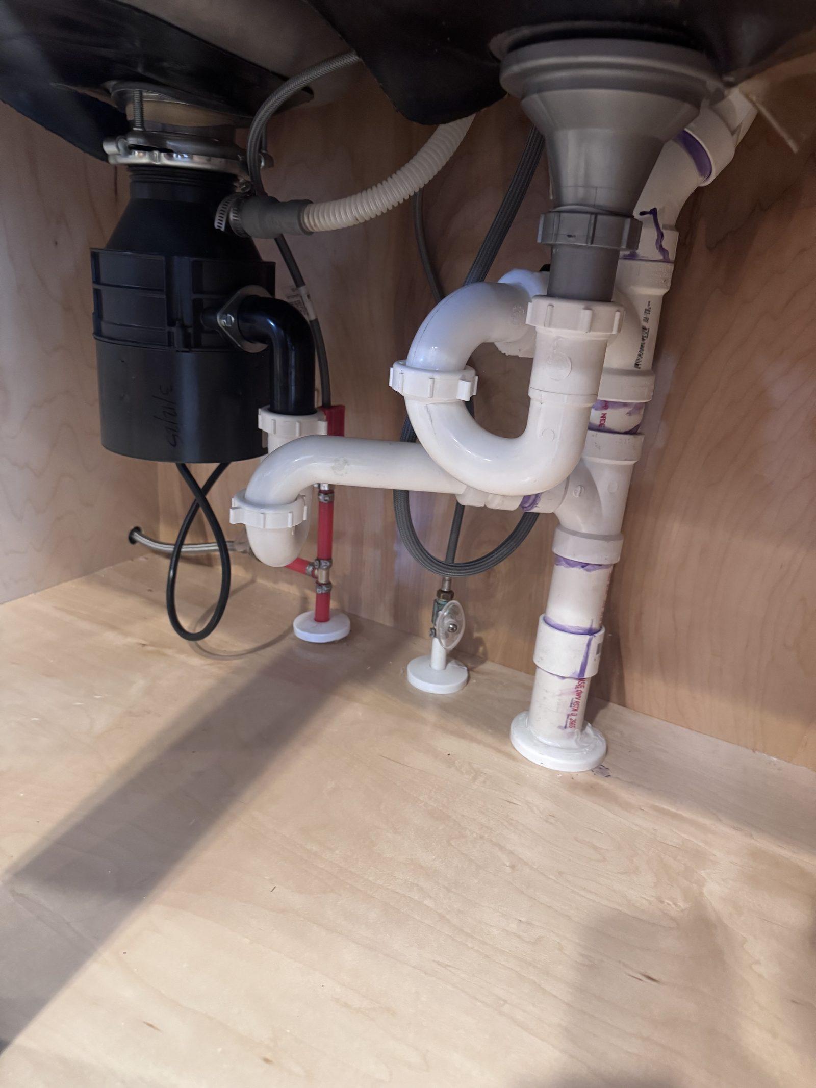 Replacement waste and supply plumbing made up under the sink with a new disposal fitted