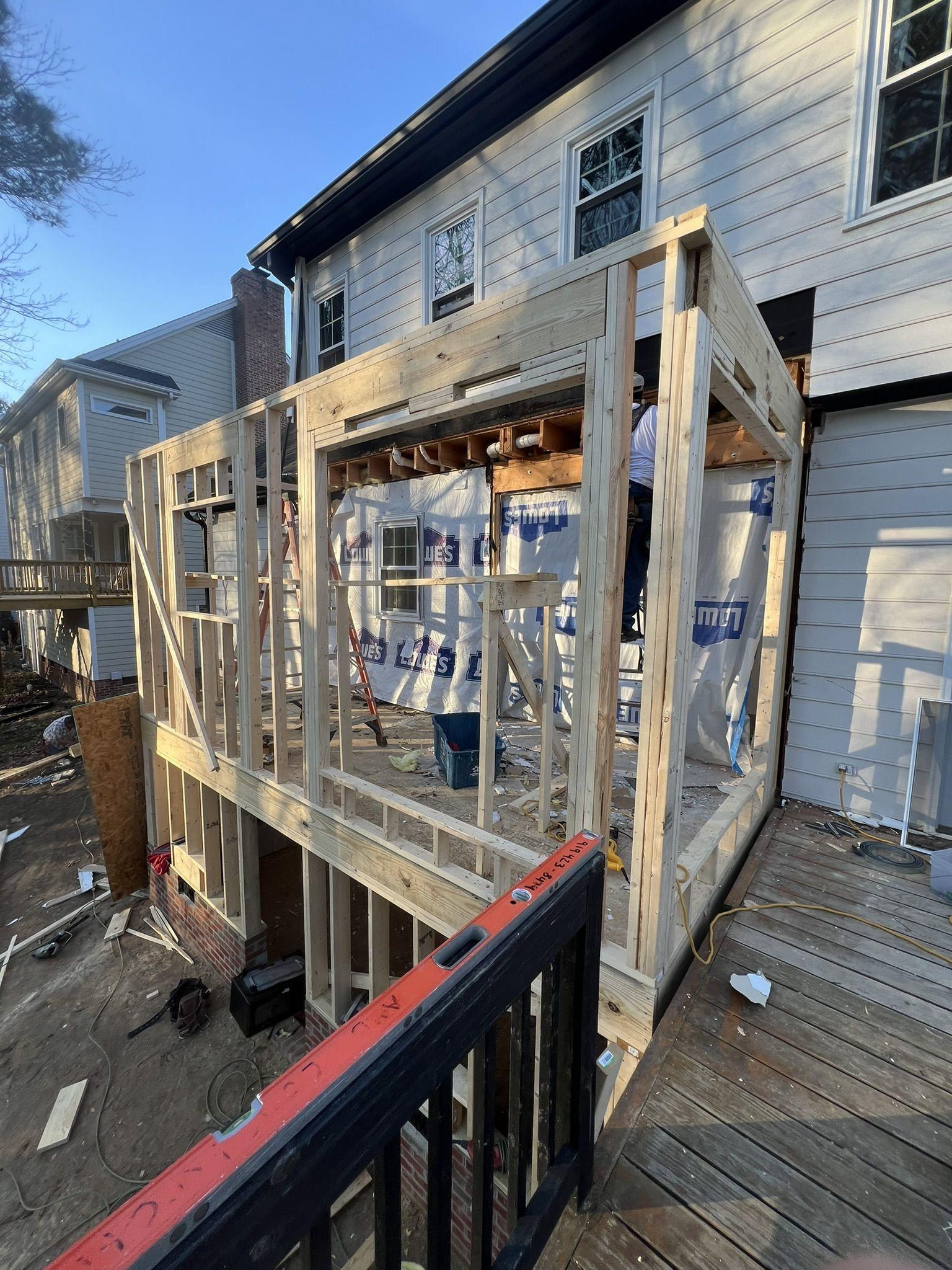 The addition framed in dimensional lumber and sheathed, tied into the existing rear wall