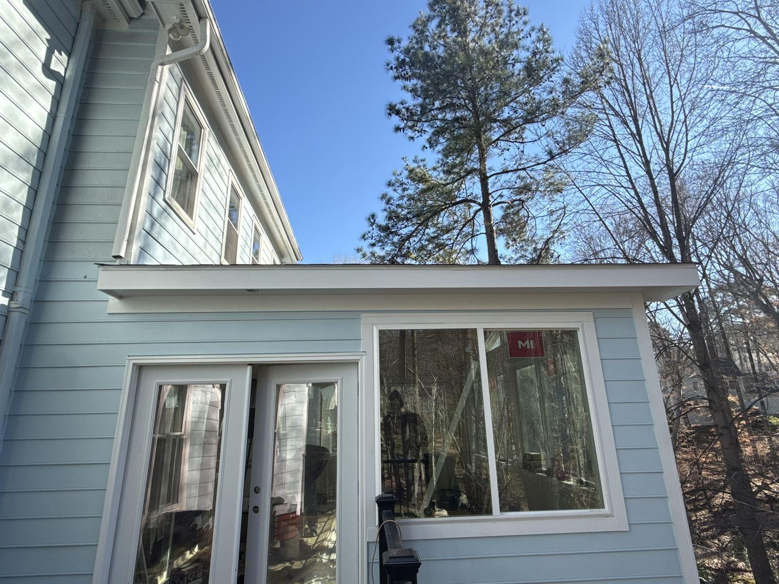 The completed sunroom enclosed, sided and glazed above the same footprint