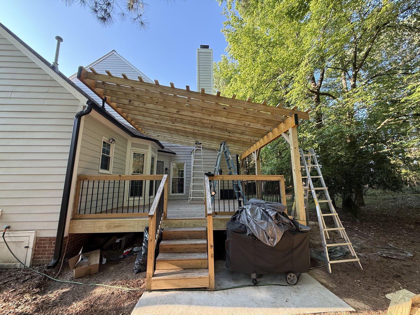 The same deck with the finished pergola overhead, its rafters spanning between the beams