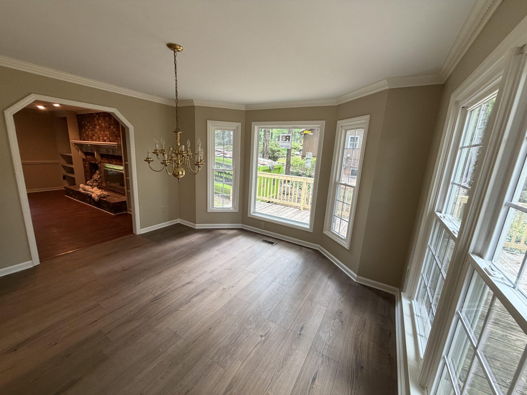 The rebuilt dining room finished with smooth ceilings, crown molding, fresh paint and new plank flooring