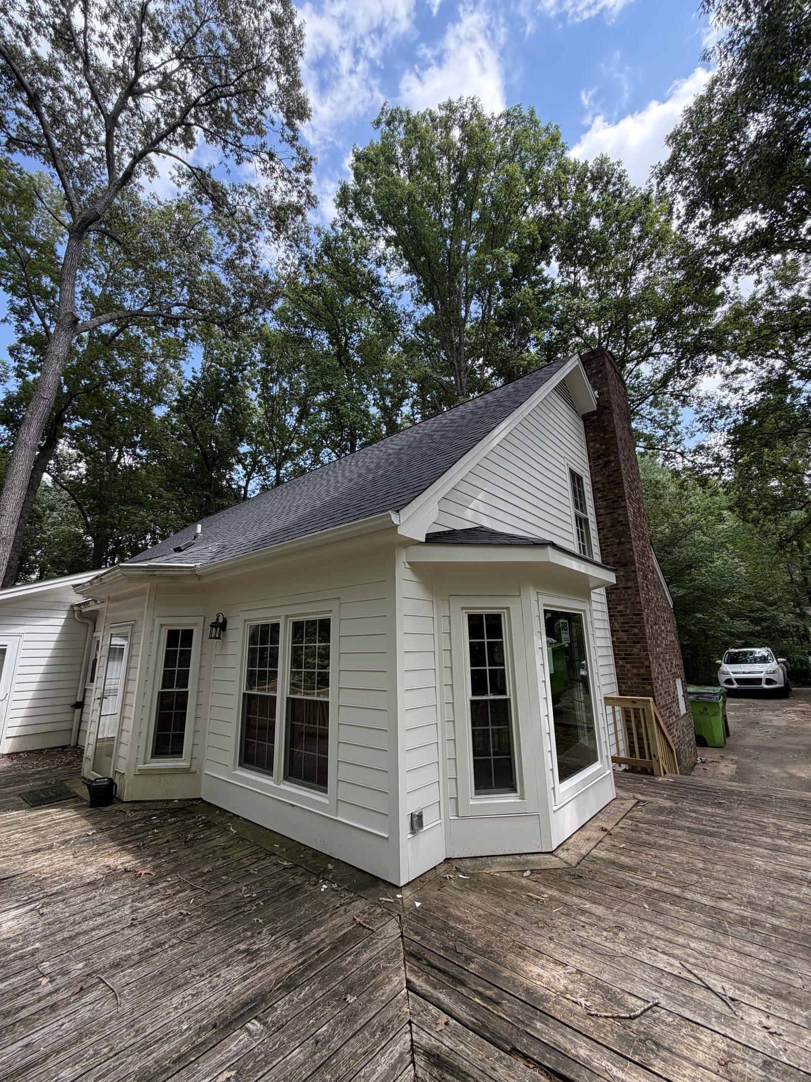 The completed exterior with new roof, siding, trim and a rebuilt bay window