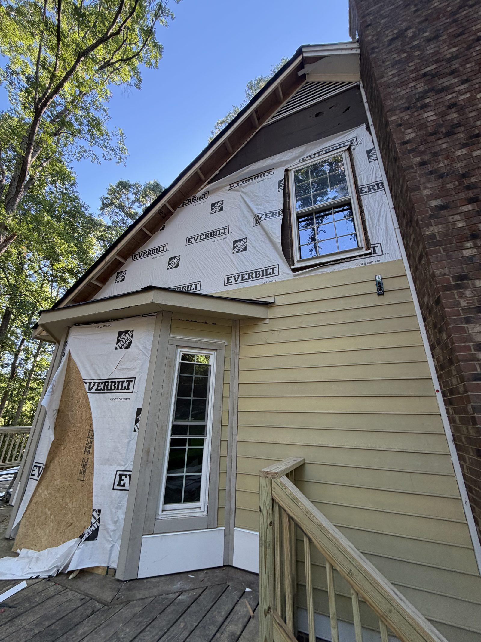 The rebuilt exterior wall framed, sheathed and wrapped with new windows set in place