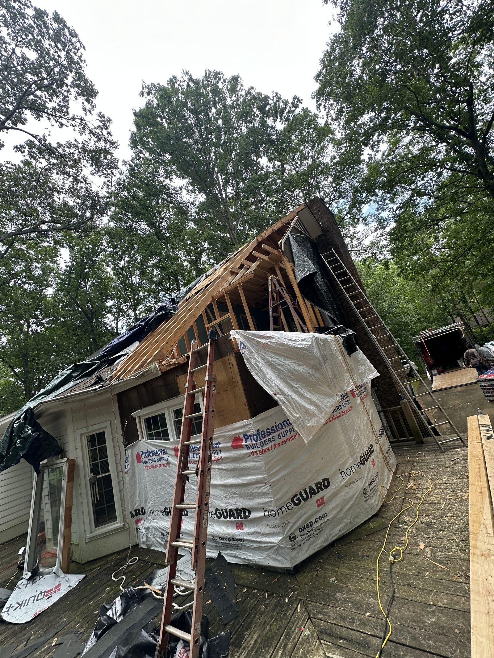 The damaged section stripped back with the roof structure removed and housewrap going on