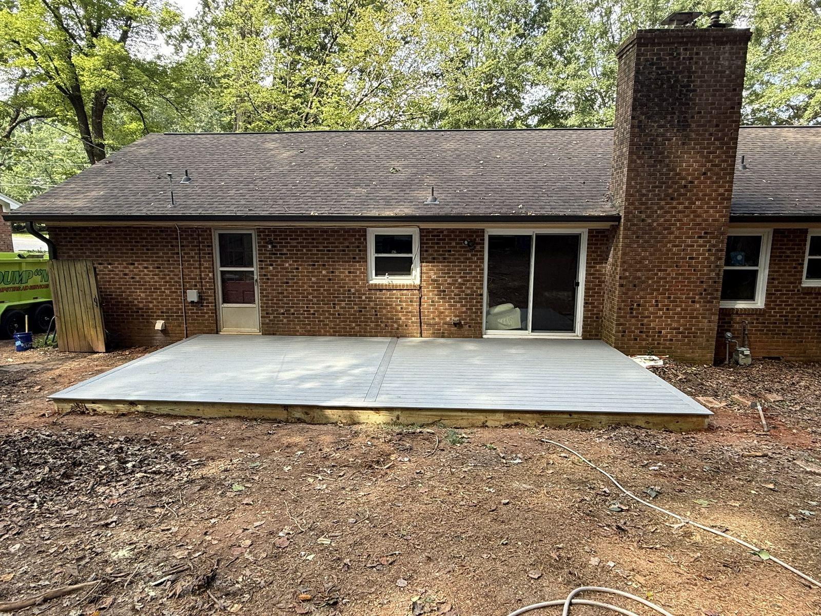 Completed composite deck built across the same rear elevation of the brick ranch house
