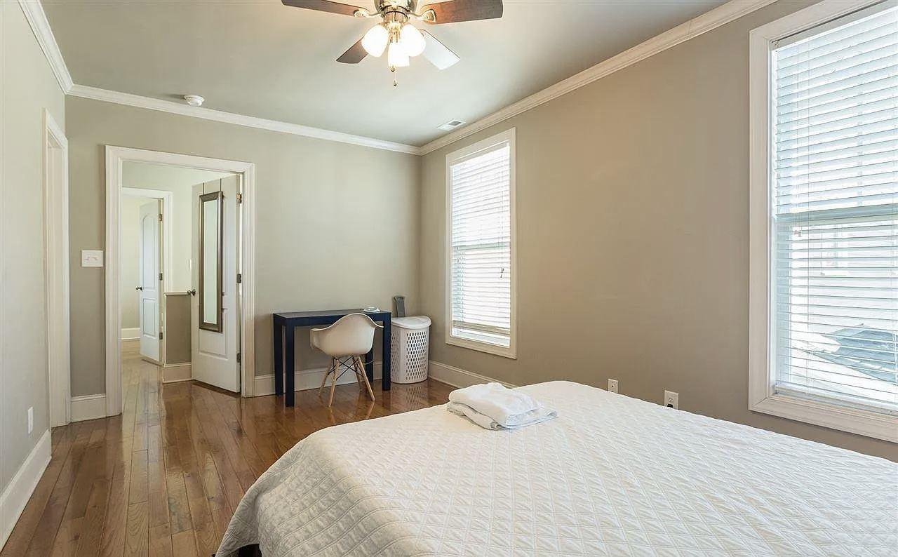 Renovated bedroom with crown molding, a desk and two windows