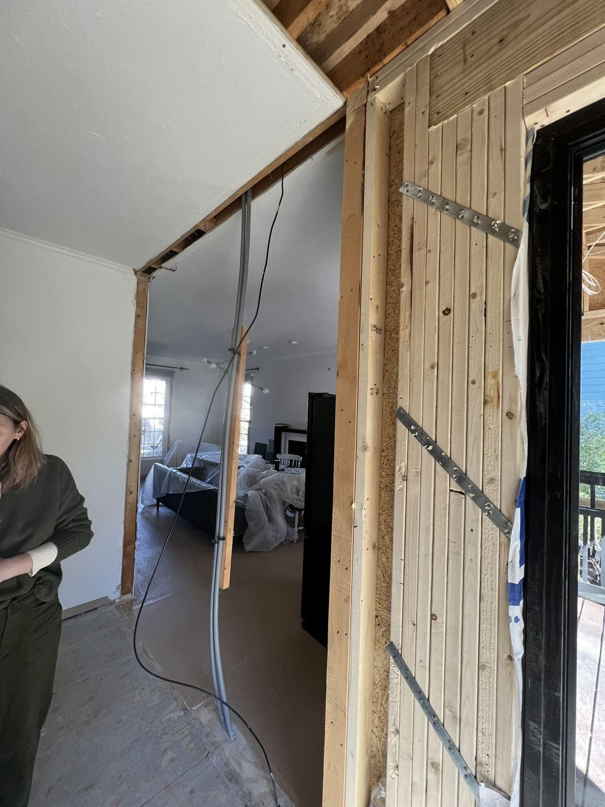 Load-bearing wall opened with temporary shoring and a new header in place